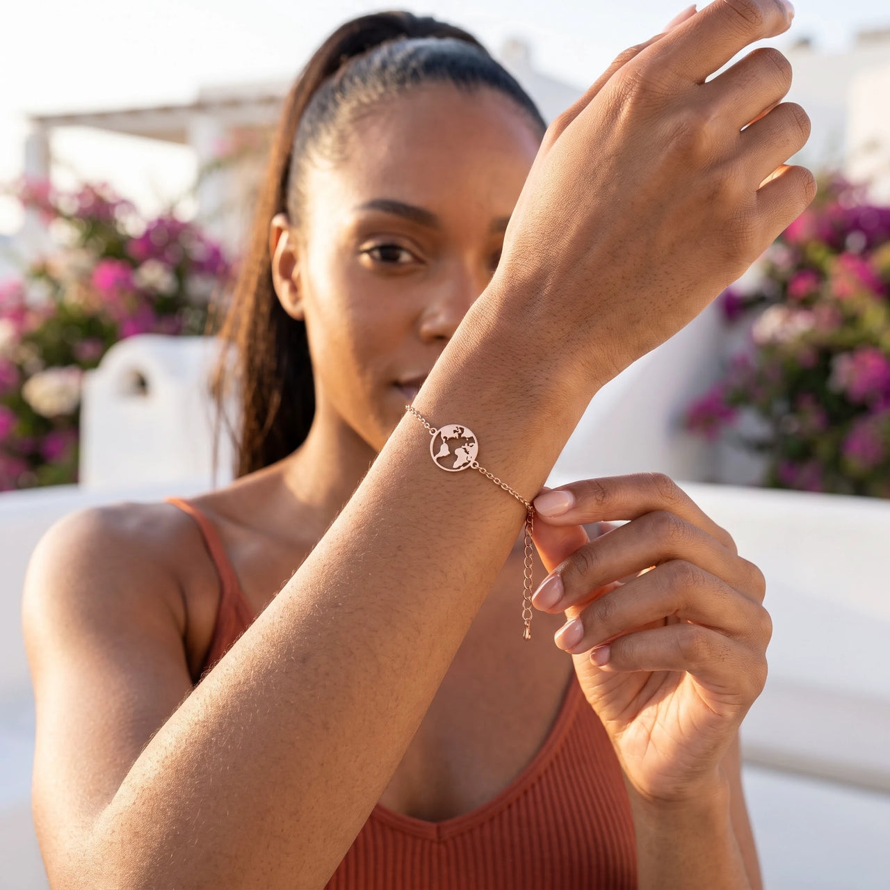 World map bracelet — worn, everyday gesture, rose gold | SKU: 22665062-rose-gold