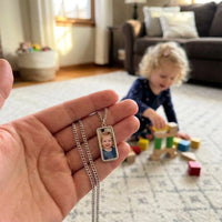 Thumbnail for Customer photo: the silver bar necklace with her daughter's photo, her daughter in the background | SKU: TPH-BARN-SILVER