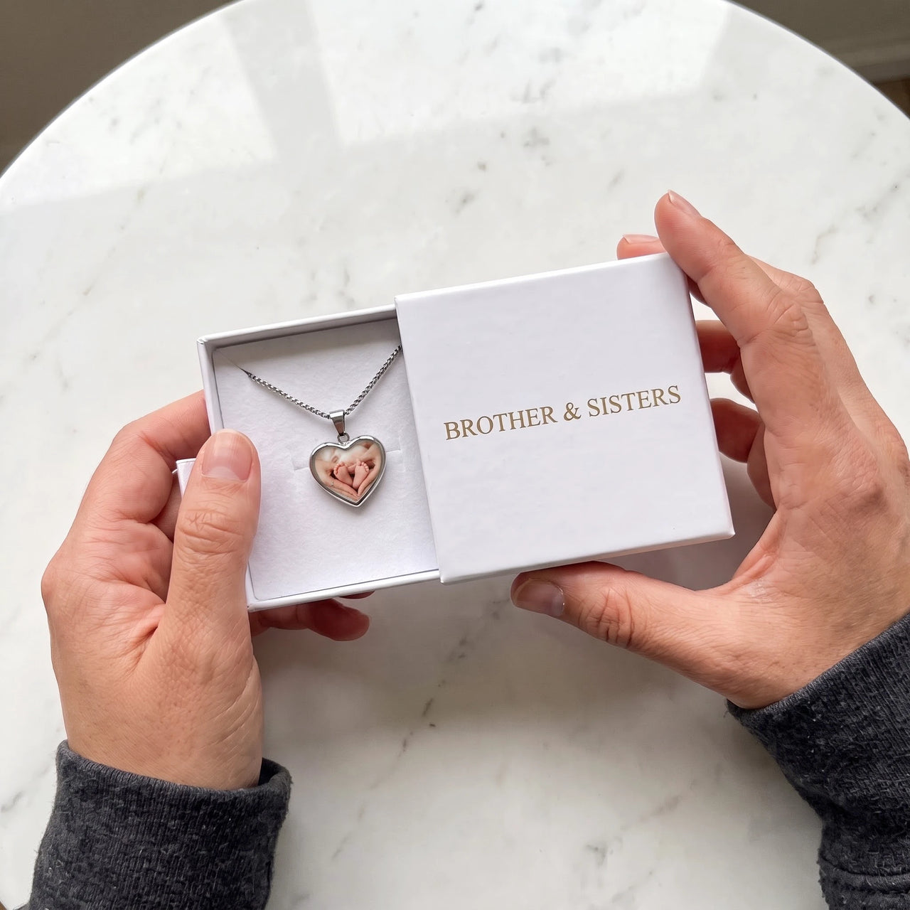 The silver heart photo necklace with a baby photo in the Brother & Sisters gift box | SKU: TPH-CHTN-SILVER-SMALL
