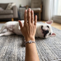 Thumbnail for Customer photo: the silver round bracelet with her bulldog's photo, her dog in the background | SKU: TPH-RNDB-SILVER