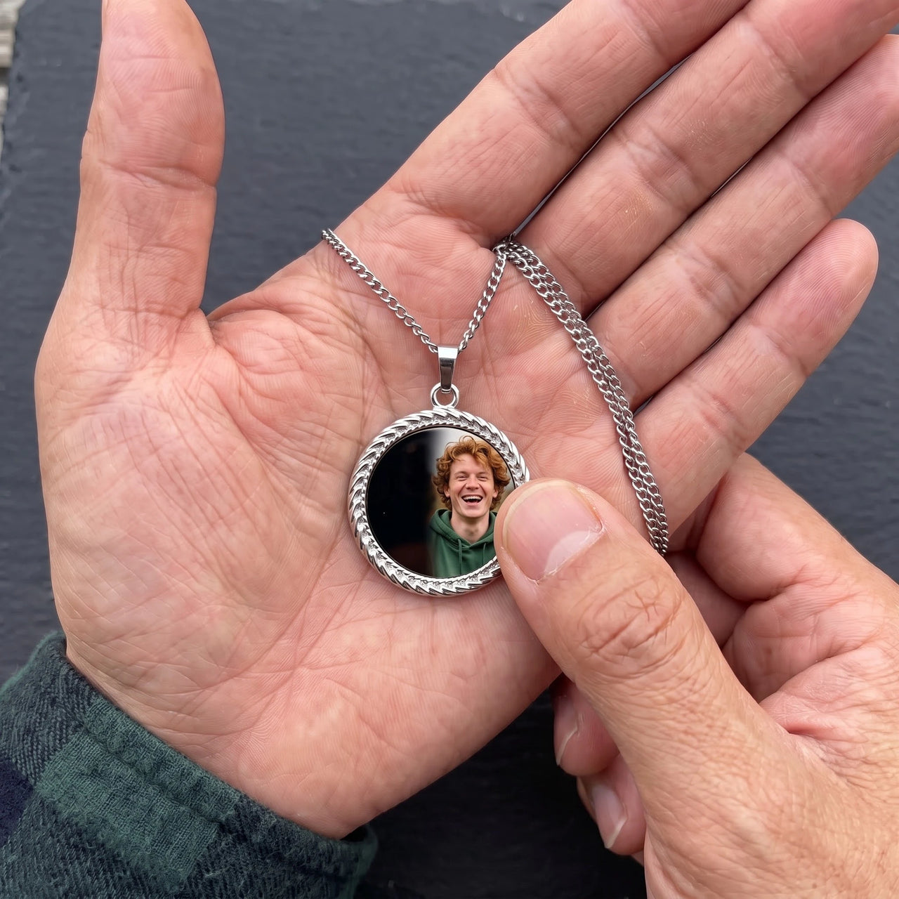 Thumb warming the silver round pendant: the hidden photo appears under the thumb while the rest stays black | SKU: TPH-RNDN-SILVER